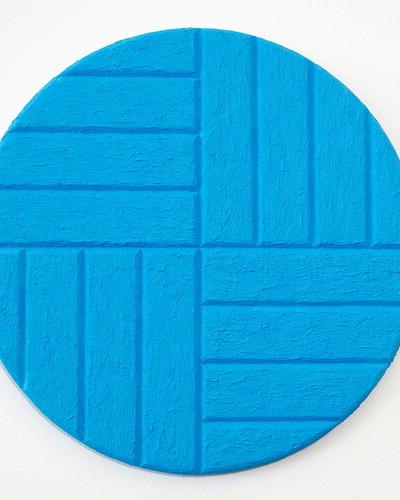 On an oval canvas is light blue color with horizontal and vertical stripes.